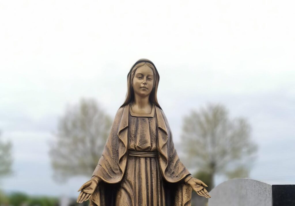 Bronzestatue der Jungfrau Maria auf einem Friedhof